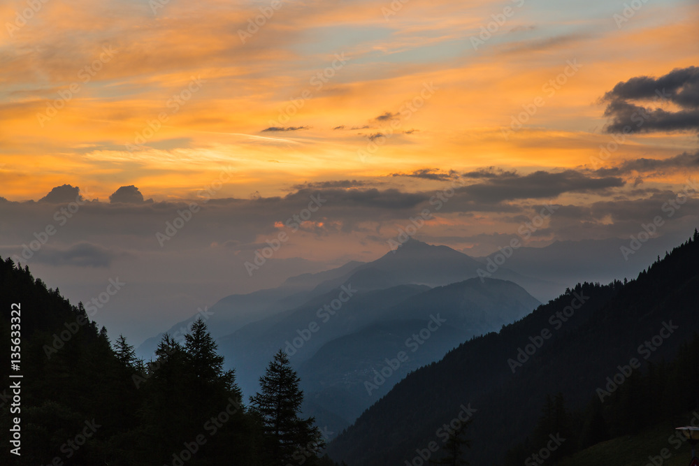 Colorful sunset in a forested valley in the mountains of Switzerland