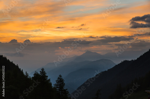 Colorful sunset in a forested valley in the mountains of Switzerland