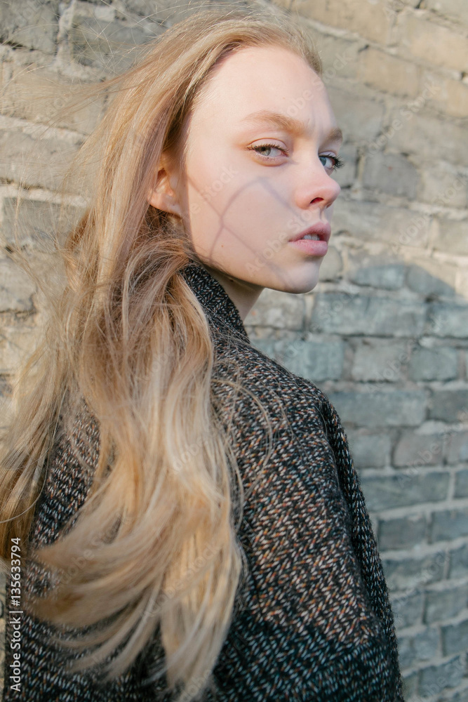 portrait of a beautiful young blonde in the autumn sun outing, against the background of a solar wall, model test portrait of a beautiful young blonde in the autumn sun outing, against the background of a solar wall, model test