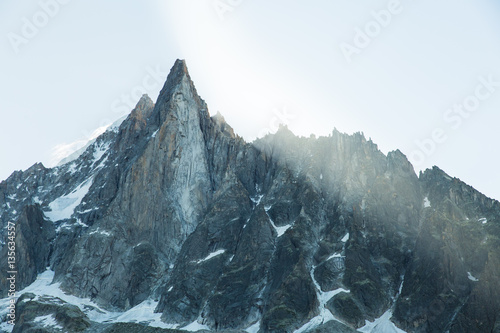 Sun breaks through the peaks of valley and glacier of Mer de Glace in the French Alps above Chamonix