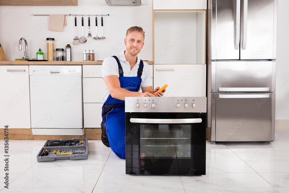 Technician Checking Oven With Digital Multimeter Technician Checking Oven With Digital Multimeter