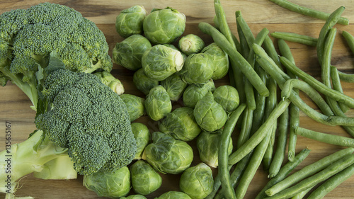 Broccoli, green beans, and brussel sprouts on wood table