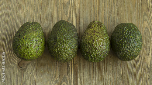 Avocados in the middle of a wood table