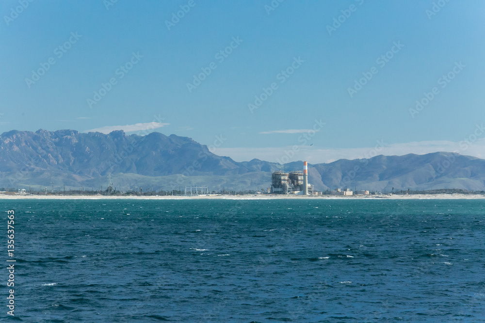 Power generating station on the coast of Ventura, California with mountains in the background