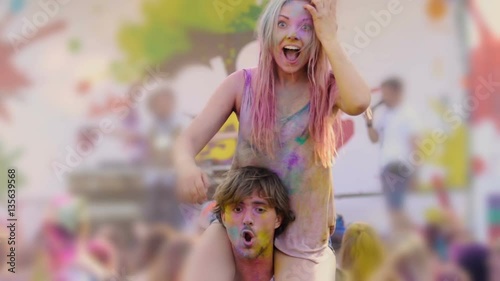 Smiling girl sitting on tall guy's shoulders, dancing and having fun at concert photo