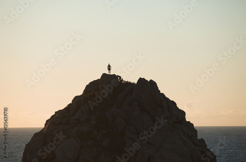 Climber reaches summit of mountain at sunset