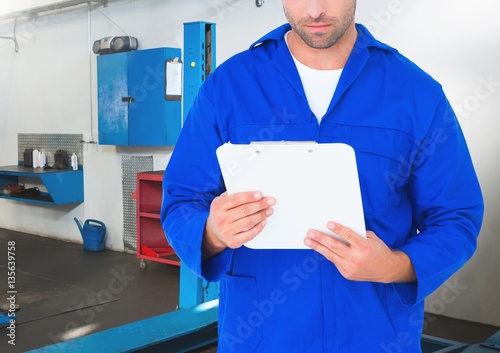 Mechanic in protective workwear holding clipboard