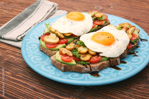 Sandwich with egg, tomato, greens, and mushrooms
