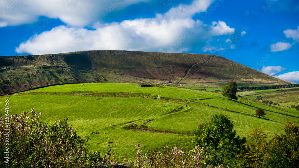 Z-shape uphill country road, Pendle Hill in distance, Summer,blue sky and white clouds, 16:9 aspect ratio, Forest Of Bowland, Lancashire, England, UK