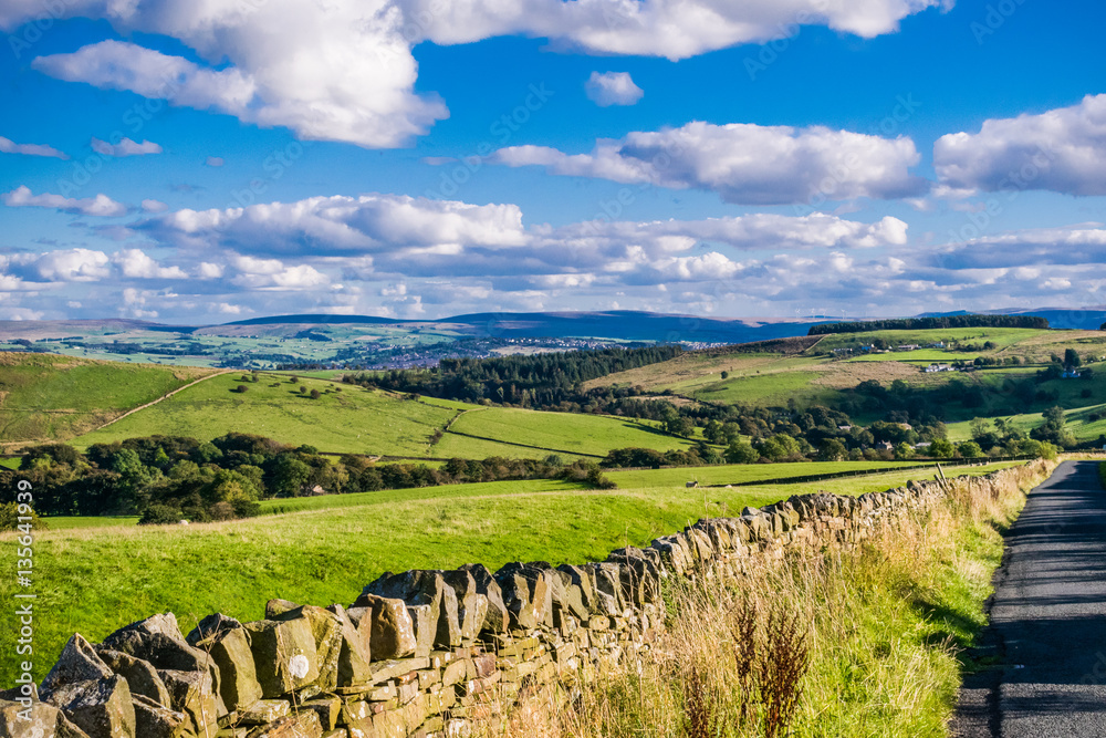 View on farms and countryside road, tarmac road, Summer, blue sky and white clouds, Forest Of Bowland, Lancashire, England, UK