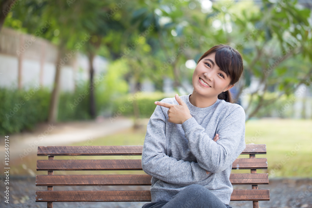 Happy woman at park pointing to copy space Happy woman at park pointing to copy space
