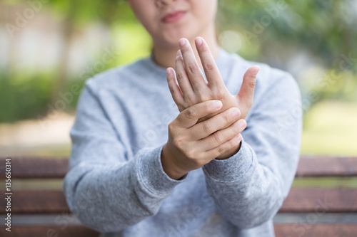 Woman has hand pain at park photo