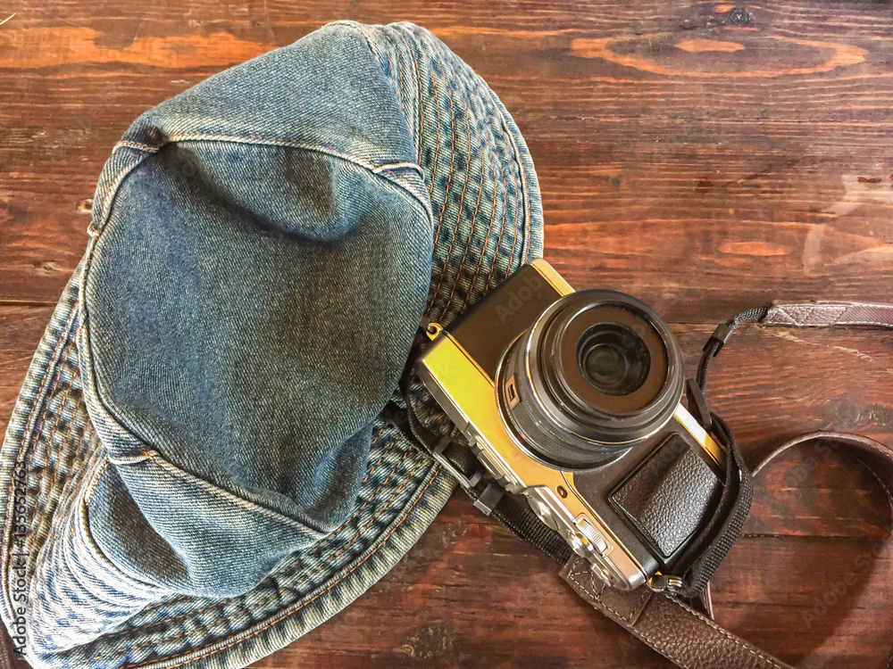 camera and hat on wooden table 