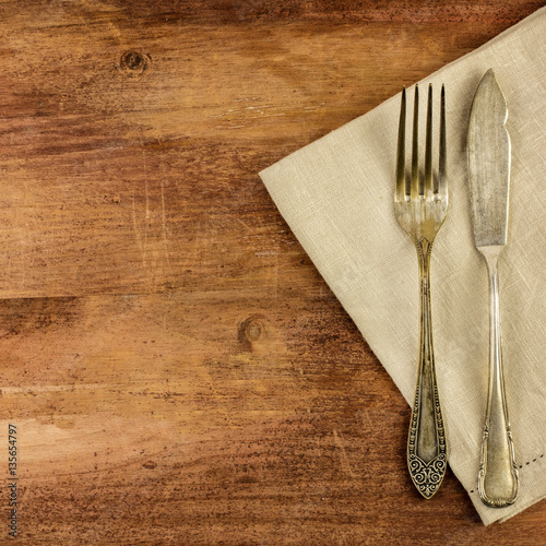 Vintage fork and knife on wooden background