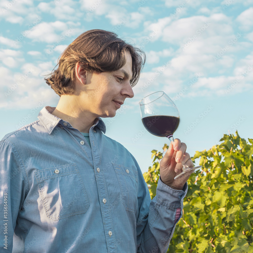 Happy winemaker tasting his wine in vineyard Happy winemaker tasting his wine in vineyard