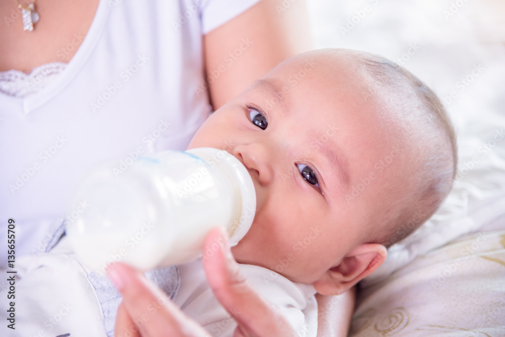Little asian child drinking milk from bottle Little asian child drinking milk from bottle