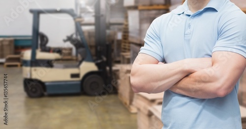 Manager standing with arms crossed in warehouse