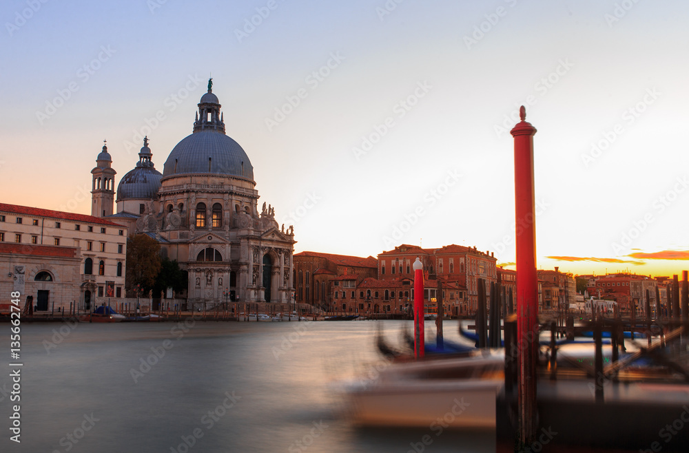Grand canal in Venice during beautiful  sunset with parked gondolas in front