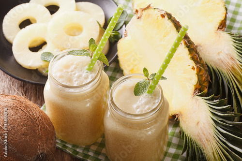 Cocktail of pineapple and coconut in glass jar closeup. Horizontal