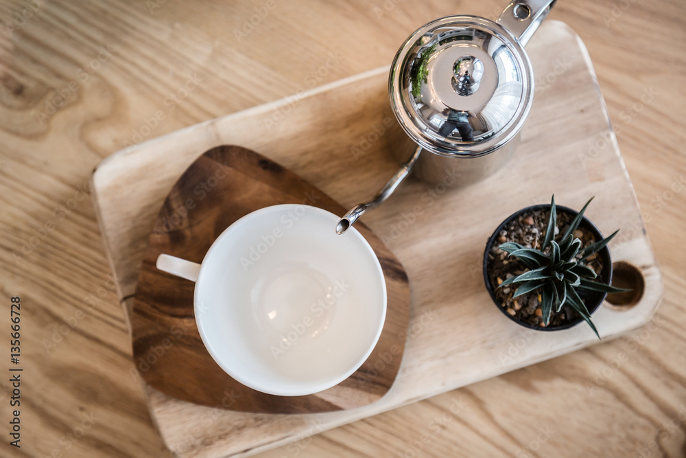 set of tea or coffee with small teapot on wooden table with room