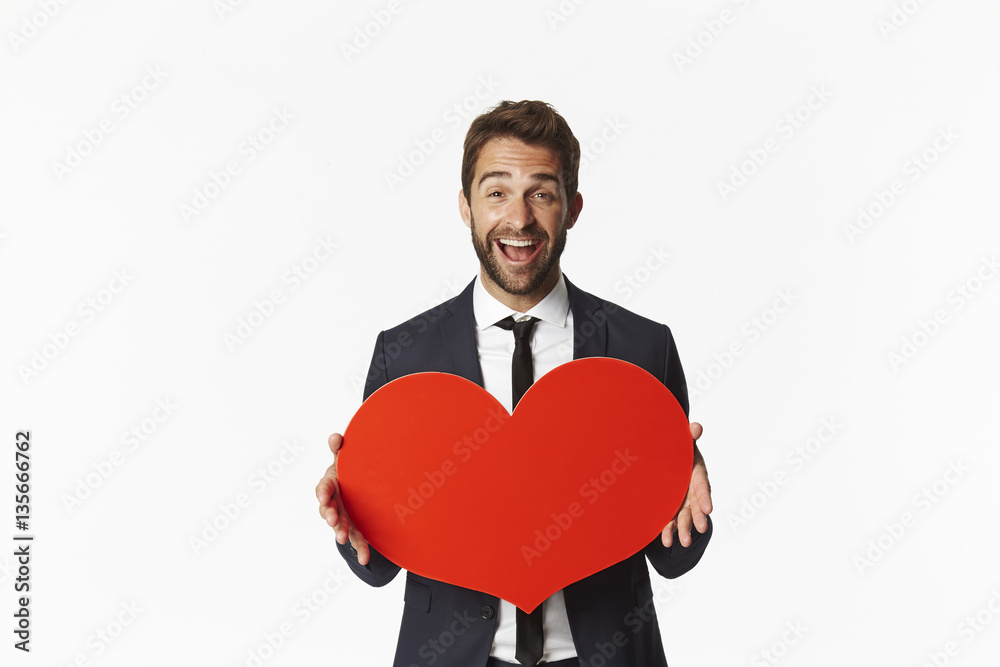 Excited valentine holding red heart in studio Excited valentine holding red heart in studio