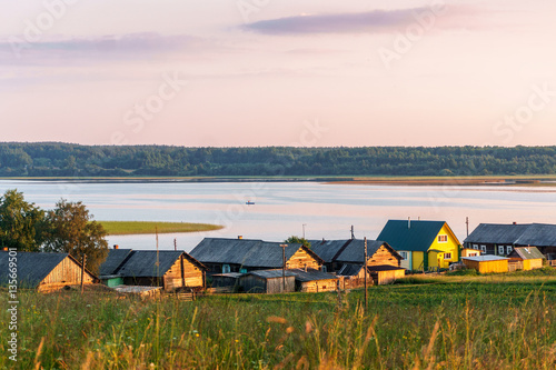 Wooden church on the top of the hill. Vershinino village sunset view. Arkhangelsk region, Northern Russia.