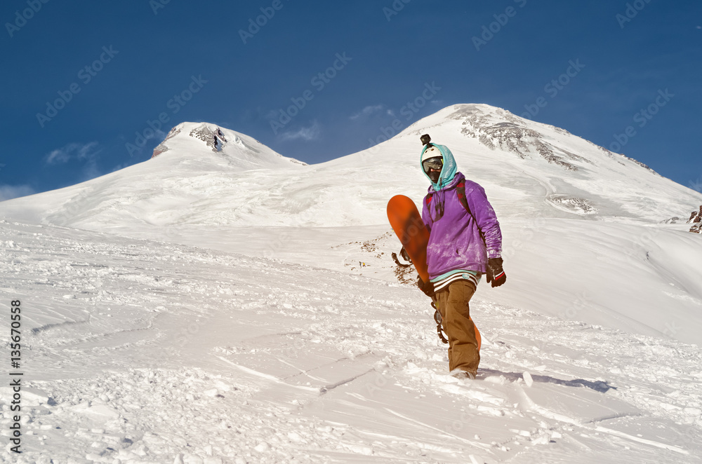 Snowboarder stands and walks on mountain slopes of an extinct volcano Elbrus