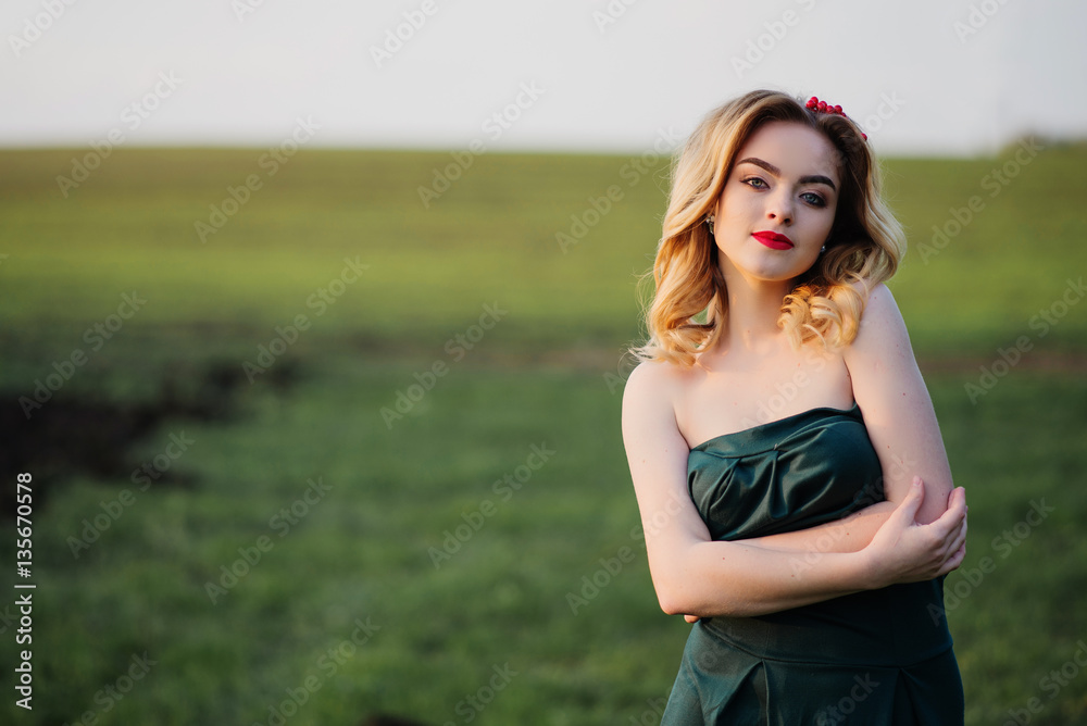 Yong elegance blonde girl at green dress on the garden in spring Yong elegance blonde girl at green dress on the garden in spring