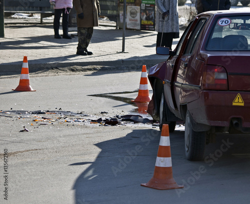 Crash broken car on accident site and orange hazzard cones around 