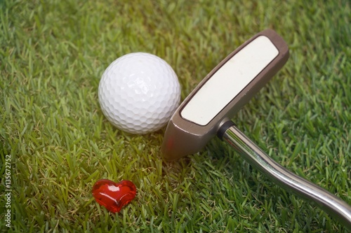 golf and putter on green grass with love sign