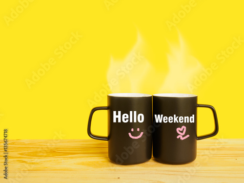 Hello weekend message on couple coffee or tea cup on desk