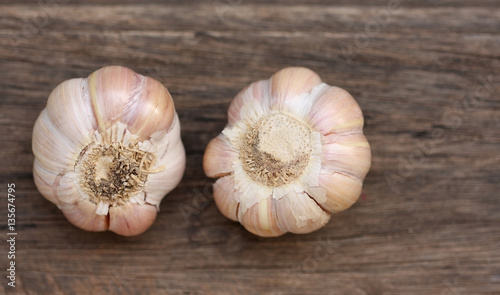 Garlic bulb and cloves on wooden background.