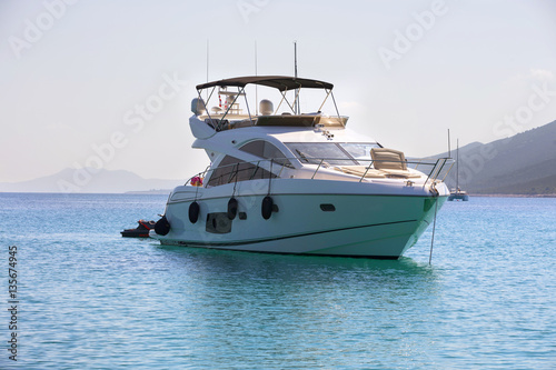 Luxury yacht in azure seas parked in a beautiful blue bay. Modern white Yacht in the sea around island on Croatia.