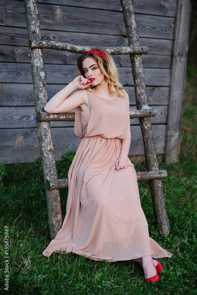 Obraz premium Yong elegance blonde girl at rose dress on the garden background