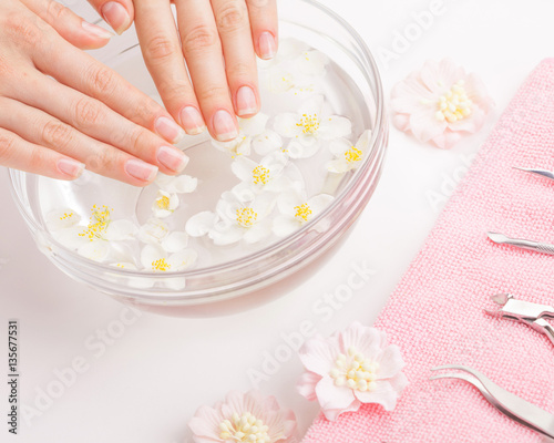 Beautiful woman's hands with manicure in bowl of water