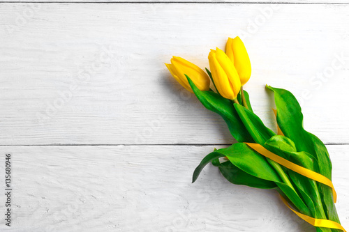 Fototapeta Naklejka Na Ścianę i Meble -  flowers yellow tulips on a white wooden board background
