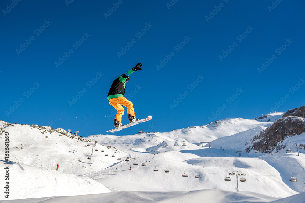 Jumping snowboarder in te Alps