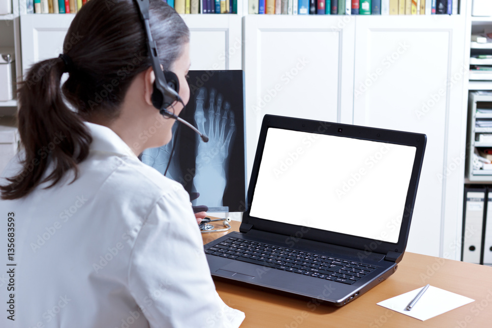 Female doctor in her surgery office with headphones in front of her ...