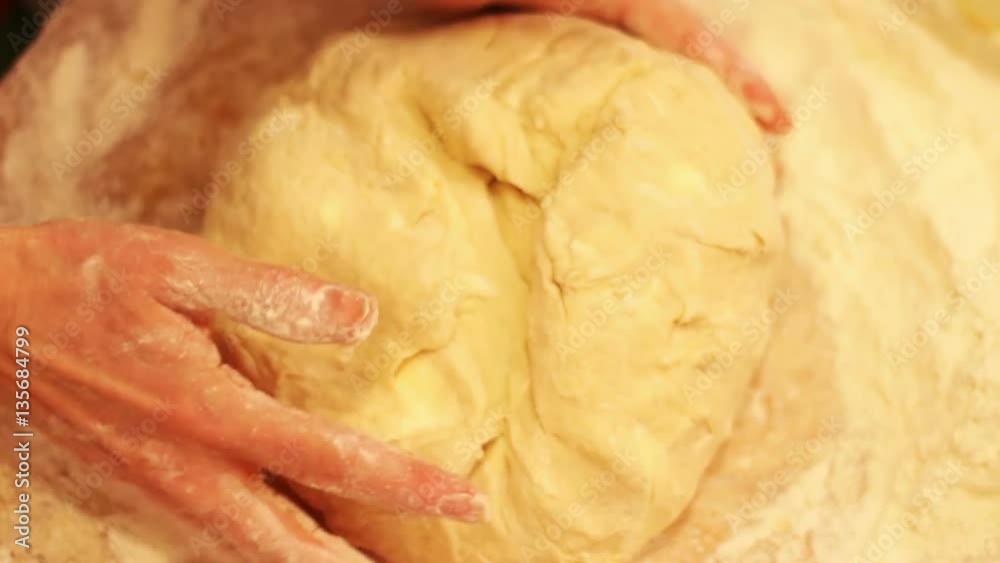 Female hands kneading dough in flour on table Female hands kneading dough in flour on table