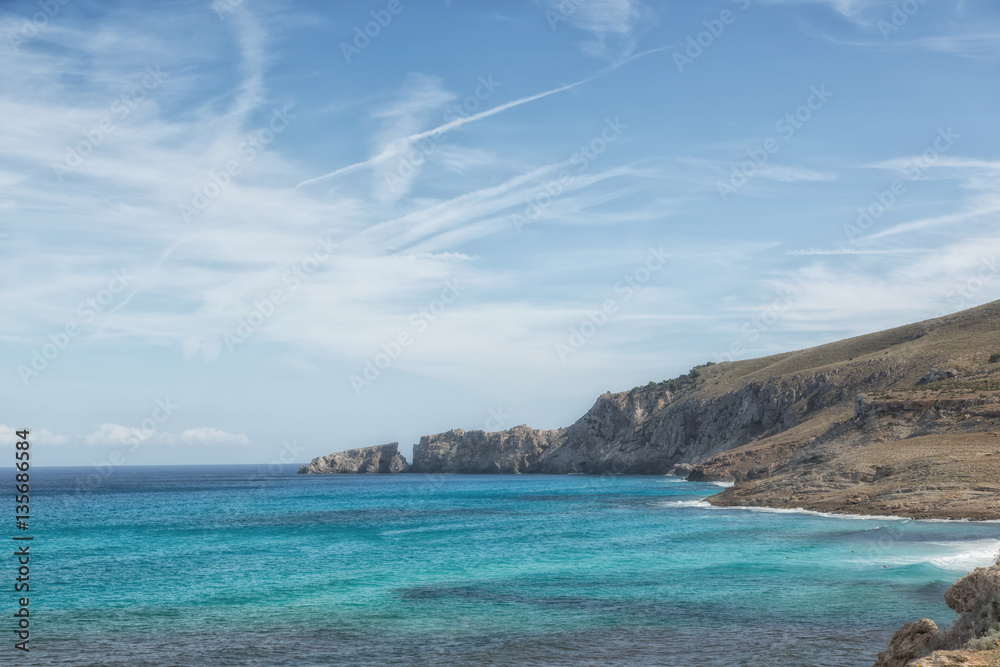 Küste Cala Mesquida, Mallorca mit blauem Himmel und Wolken