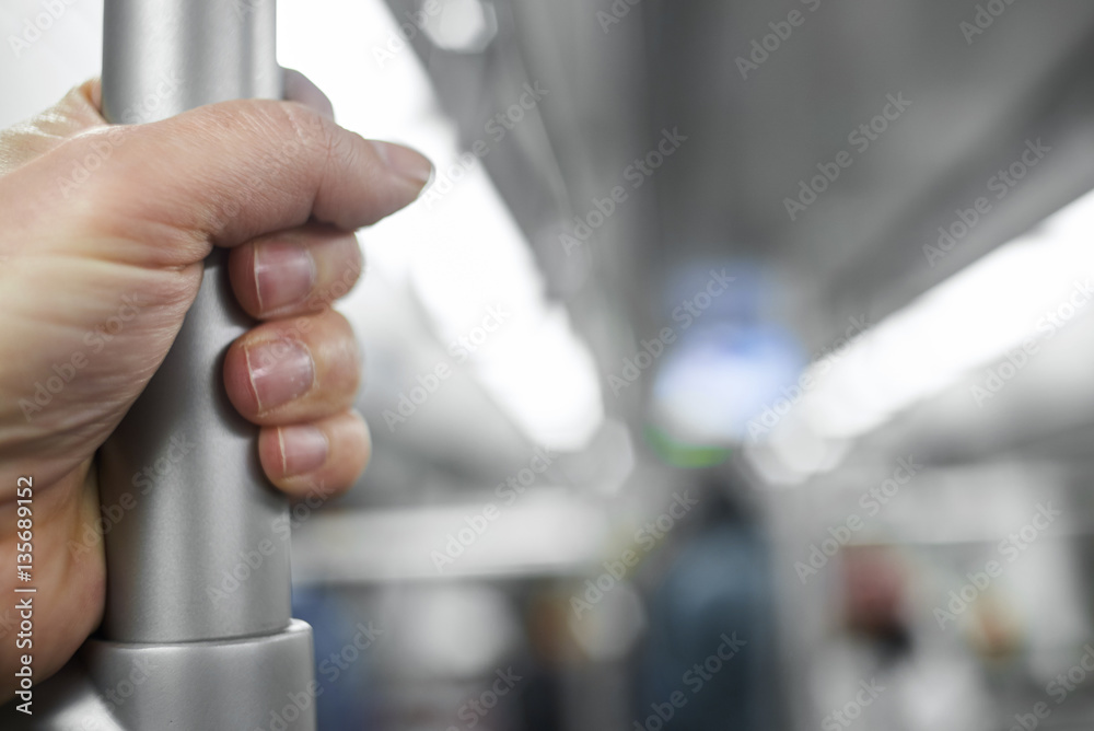 Standing passenger inside metro train.