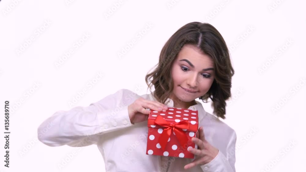 Cheerful happy woman opening gift box isolated on a white background Cheerful happy woman opening gift box isolated on a white background