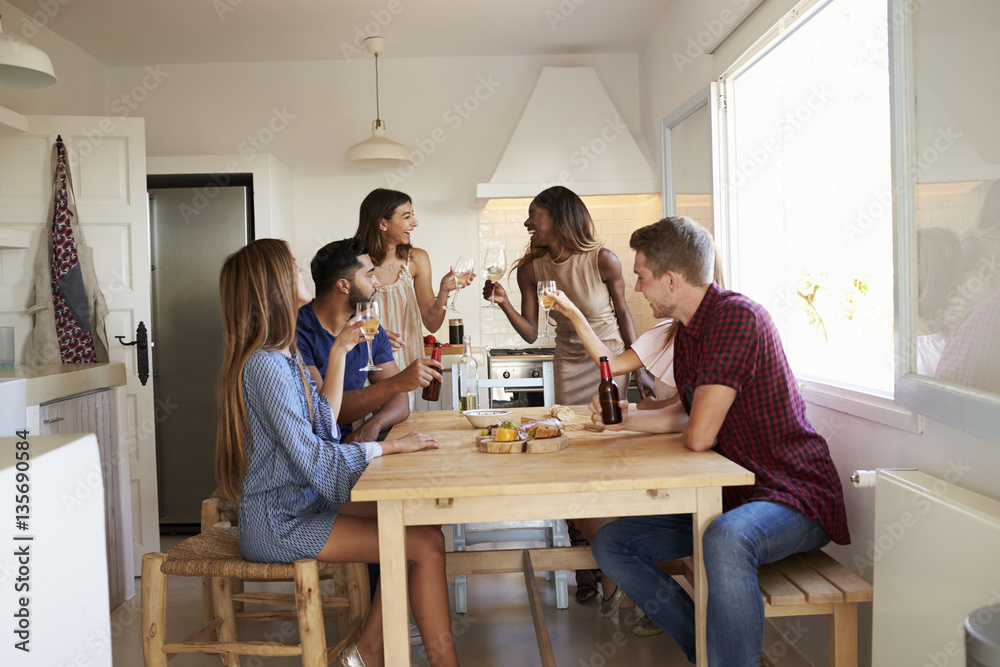 Group of friends at a casual dinner party making a toast