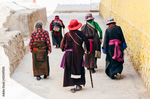 Qinghai, China - 8 October 2016: Local ladies in tibetan clothes - chuba and  colorful hats in buddhist Longwu (Rongwo) Monastery in Qinghai, China