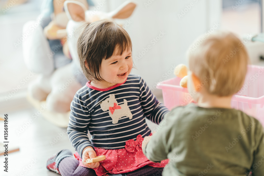 little girl and boy playing with toys by the home - obrazy, fototapety, plakaty 