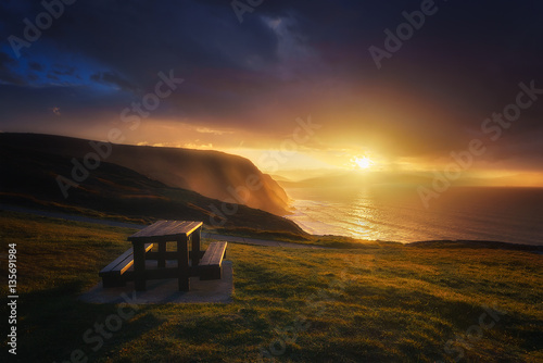 picnic table in Barrika coast at sunset photo