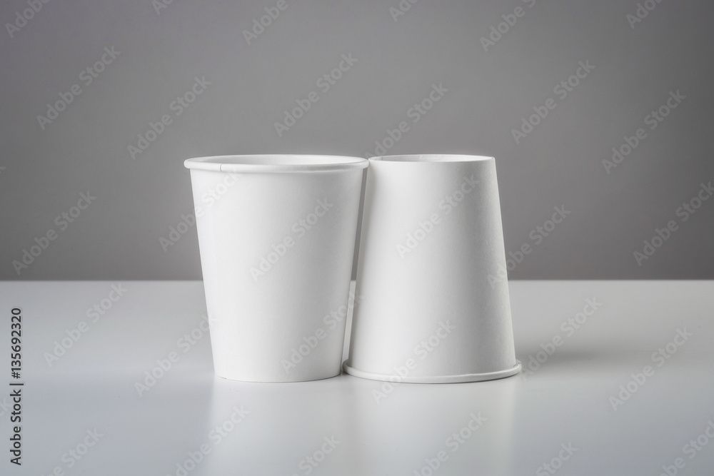 Some white cup with biscuit on gray table Some white cup with biscuit on gray table