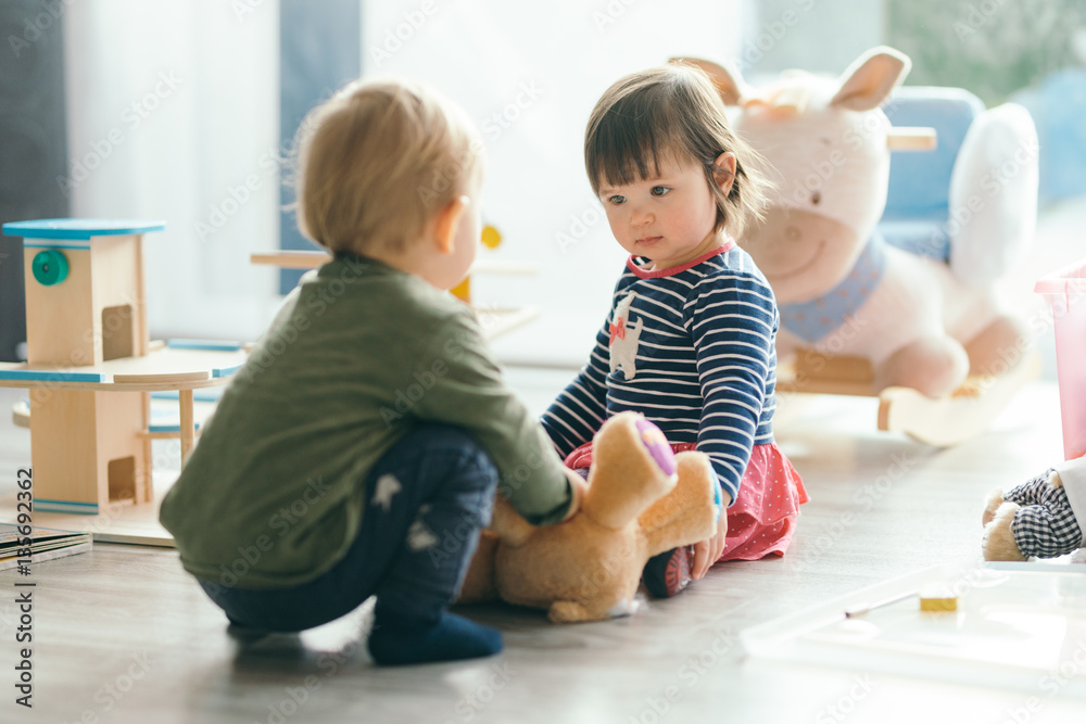 little girl and boy playing with toys by the home little girl and boy playing with toys by the home