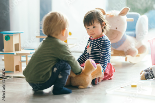 little girl and boy playing with toys by the home