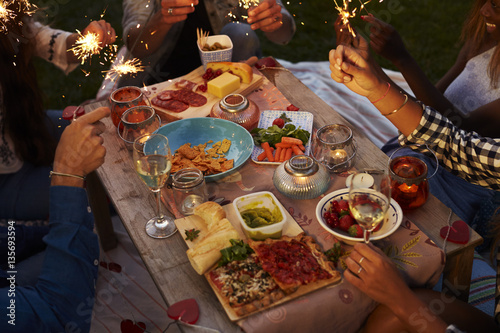 Friends With Sparklers Eating Food And Enjoying Party